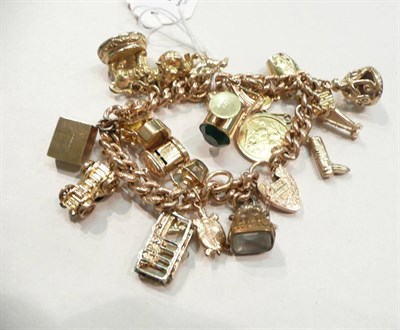 Lot 266 - A charm bracelet hung with assorted charms including a 1905 half sovereign and four loose charms