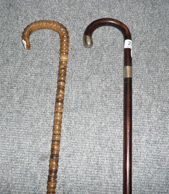 Lot 278 - A silver mounted walking stick and a vertebrae walking stick.