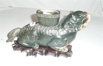 Lot 332 - A carved greenstone mythical beast on a hardwood stand