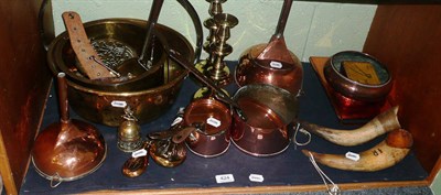 Lot 424 - A shelf of brass and copper including two powder flasks, two funnels, a preserve pan, a pair of...