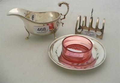 Lot 468 - Silver sauce boat, silver dish with ruby container and a toast-rack