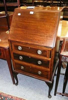 Lot 602 - An Edwardian mahogany small bureau, a mahogany two door cupboard and a two-tier occasional table