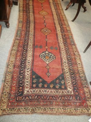 Lot 622 - North West Persian runner, the madder field with a column of diamond shaped medallions