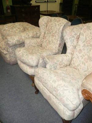 Lot 668 - Two wing armchairs and a buttoned tub chair and a pouffee upholstered in floral weave