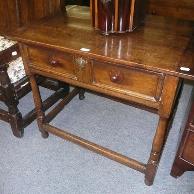 Lot 740 - A 17th century style oak side table, the rectangular top above a single frieze moulded panel...