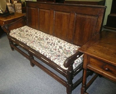 Lot 741 - An 18th century oak settle with strung cushion seat and panelled back