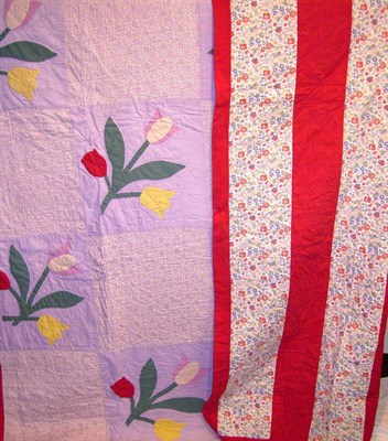 Lot 1030 - Reversible Patchwork And Tulip Appliqued Quilt with red and floral stripes to the reverse;...