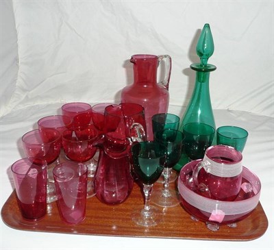Lot 2 - A tray of coloured glass including three cranberry jugs, a white trail-decorated cream jug and...