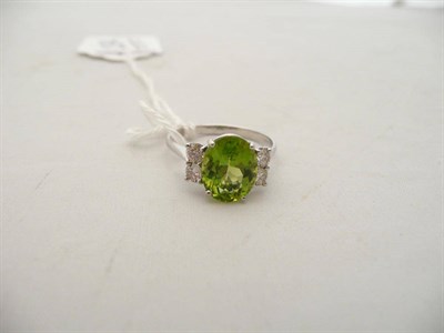 Lot 134 - A 14 carat white gold peridot and diamond ring