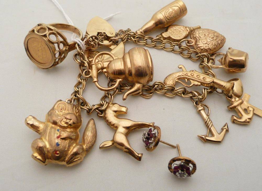 Lot 154 - A 9 carat gold charm bracelet hung with eleven charms, 22.5g approx., a 9 carat gold coin ring...