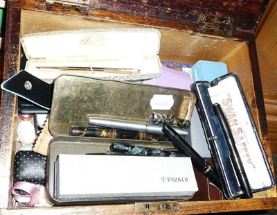 Lot 244 - A box of miscellaneous including a 9 carat gold brooch, vintage fountain pens, gold nibs,...