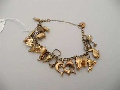 Lot 265 - 9 carat gold charm bracelet, hung with 23 charms, most are gold, 18.2g approximately