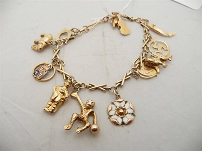 Lot 472 - A gold charm bracelet hung with 12 charms, 18.8g approximately