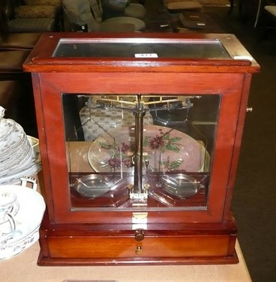 Lot 477 - A mahogany cased chemists balance with drawer to base containing weights