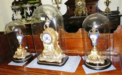 Lot 498 - A gilt metal and porcelain mounted mantel clock with garniture, all under domes (a.f.)