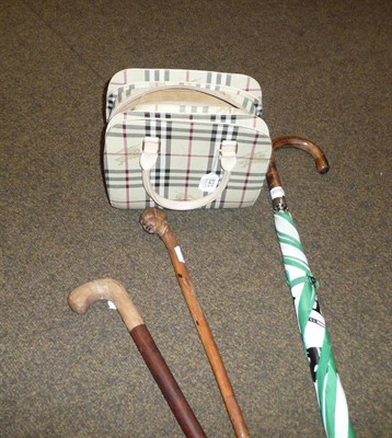 Lot 521 - A Burberrys hand bag, two carved sticks and a Lloyds umbrella