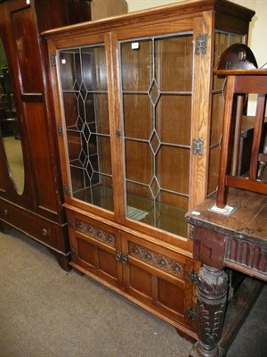 Lot 645 - An oak leaded glazed bookcase, a reproduction mahogany butlers tray on stand, a piano stool, a...