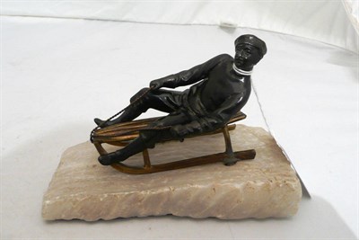 Lot 83 - A bronze gilt figure of a man on a sledge, alabaster base (possibly Russian)