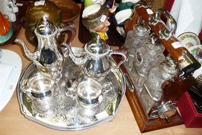 Lot 124 - A three bottle tantalus and a four piece silver plated tea set and tray