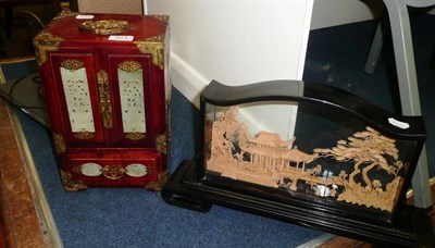 Lot 321 - A small lacquered cabinet and a relief carving of a houses and figures in a case