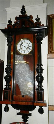 Lot 353 - A walnut and ebonised wall clock with key and pendulum