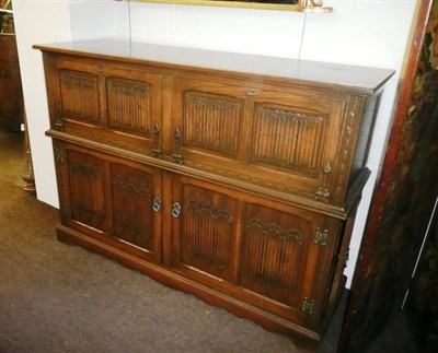 Lot 372 - A reproduction oak linen fold cabinet