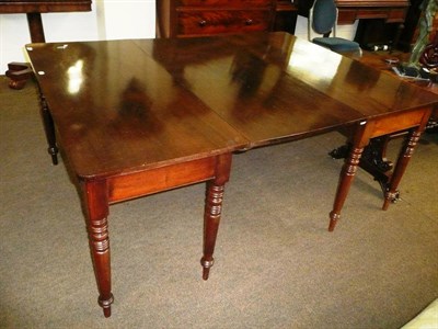 Lot 416 - An early 19th century mahogany two section dining table with leaf