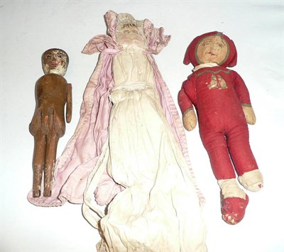 Lot 5 - Wooden jointed doll with painted and carved face, fabric doll with embroidered face and another...