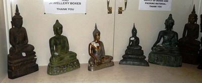 Lot 134 - Four metal figures of seated Buddhas and two wooden examples