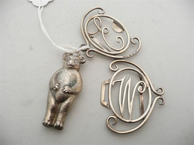 Lot 188 - A silver teddy bear rattle and a silver belt clasp with 'E W' monogram