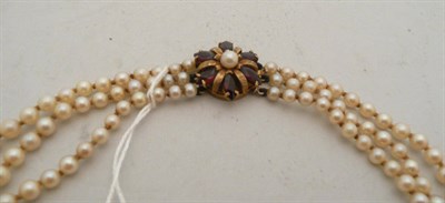 Lot 213 - Three strand cultured pearl necklace with garnet clasp