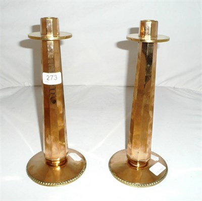 Lot 273 - A pair of Arts and Crafts brass candlesticks with octahedron stems on circular gadrooned edged...