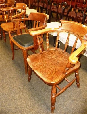 Lot 573 - An oak tub chair and two captain's chairs