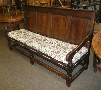 Lot 592 - An 18th century oak settle with strung cushion seat and panelled back