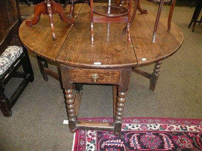 Lot 595 - An 18th century oak drop-leaf dining table