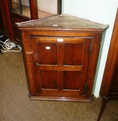 Lot 624 - An oak panelled hanging corner cupboard