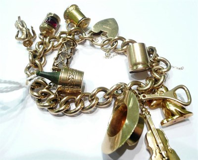 Lot 62 - A 9ct gold curb and lock bracelet hung with ten charms