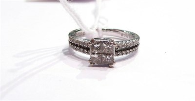 Lot 135 - A princess cut diamond cluster ring with diamond set tramline shoulders