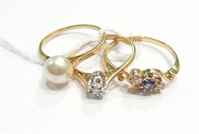 Lot 137 - A diamond solitaire ring, a sapphire and diamond three stone ring and a cultured pearl ring