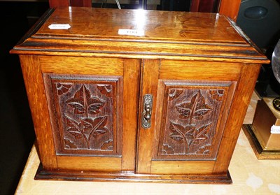 Lot 194 - A late Victorian carved oak smokers cabinet and contents