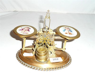 Lot 262 - Pair of brass postal scales inset with porcelain Cupid panels, three weights