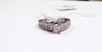 Lot 322 - A princess cut diamond solitaire ring with princess cut diamond set shoulders stamped 'PT 950'