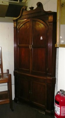 Lot 410 - A George III mahogany floor standing corner cupboard