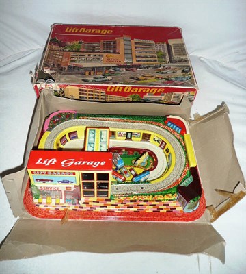 Lot 1120 - A Boxed Technofix Lift Garage, with multicoloured plastic base, tinplate garage and four...