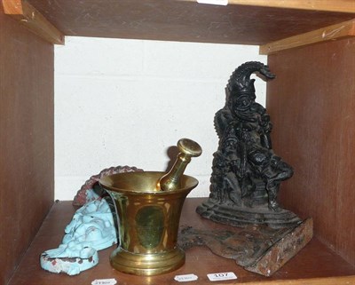 Lot 107 - Cast iron Mr Punch door-stop and two others and a brass pestle and mortar