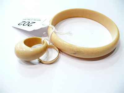 Lot 202 - An 18 carat gold band ring, an ivory bangle and an ivory ring