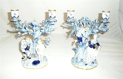 Lot 291 - A pair of Meissen twin branch candelabra modelled as bird's egg hunting youths (a/f)