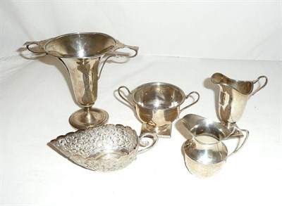 Lot 295 - A silver twin handled cup, Birmingham, 1908, a silver cream jug and sugar bowl en suite, London...