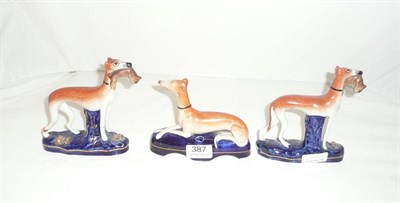 Lot 387 - Staffordshire greyhound, pair of greyhound figures (3)