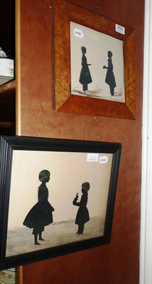 Lot 402 - A silhouette cutout double child portrait, circa 1840, depicting a young girl standing before a...